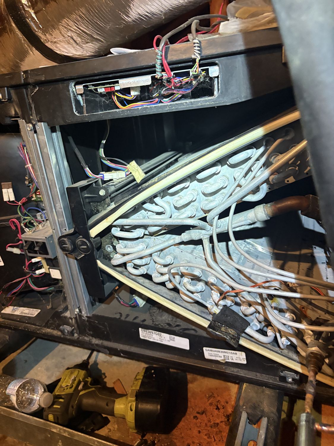 A technician servicing an open evaporator coil